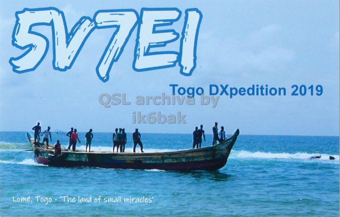 Front QSL card, of 5V7EI to IK2GRA, March 17, 2019, CW mode. The QSL image contains the following objects: Boat, Yacht, Person, Water, Sea. And contains this text: QSL archive LAS Togo DXpedition 2019 by ik6bak Lomé, Togo - The land of small miracles'.