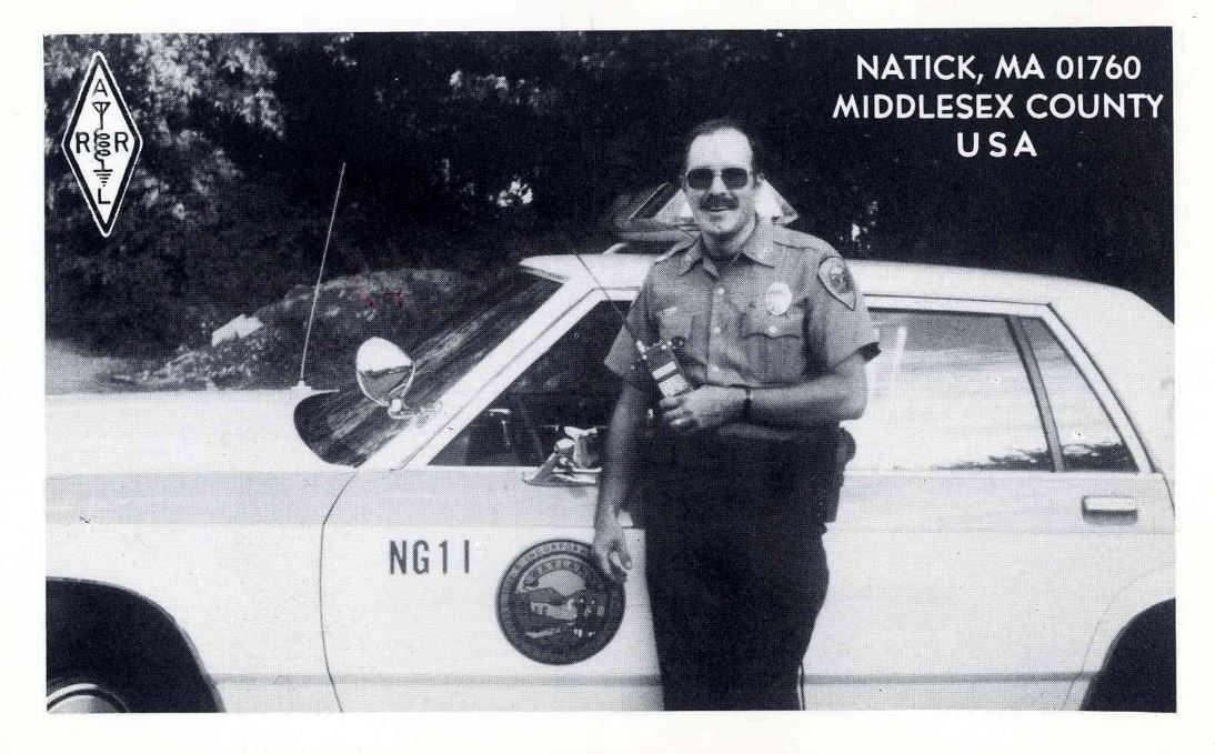 Front QSL card, of NG1I to IK2GRA, September 12, 1991, CW mode. The QSL image contains the following objects: Adult, Male, Man, Person, Car. And contains this text: NATICK, MA 01760 A MIDDLESEX COUNTY USA L NG11 NATICK, MA 01760 A MIDDLESEX COUNTY USA L NG11.